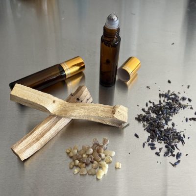 Essential oil glass bottles with display of raw ingredients on steel table